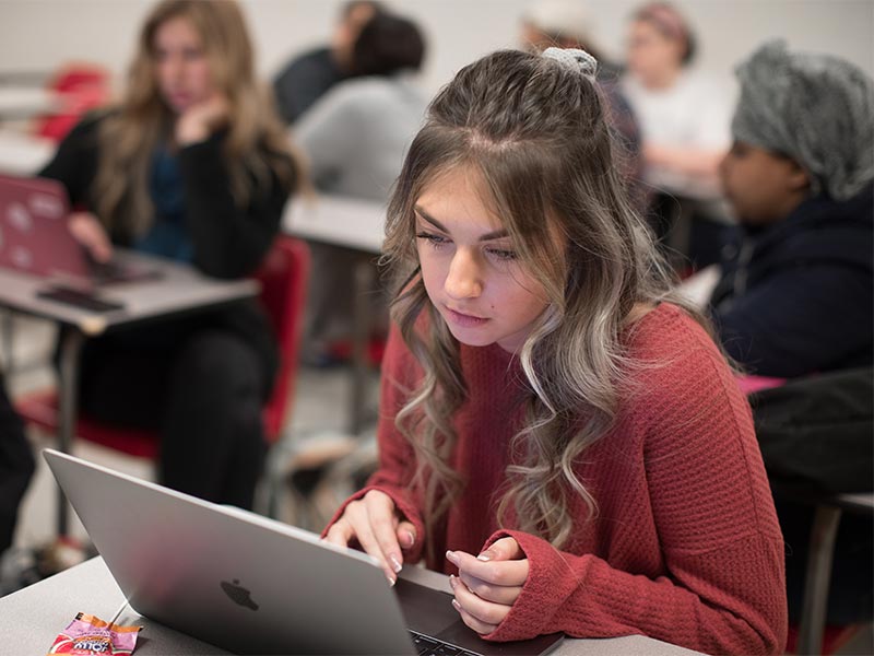 A student using a laptop in a classroom
