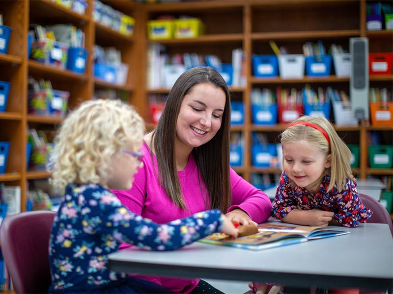 An education student teaching children to read