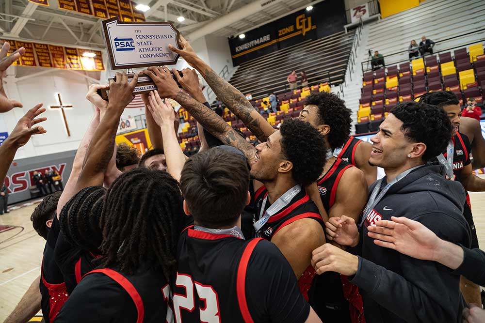 PennWest California men’s basketball team celebrating a PSAC Championship victory secured in the final seconds.