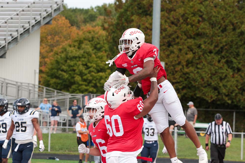 PennWest Edinboro football student athletes celebrating a fourth-quarter comeback victory and game-winning touchdown.