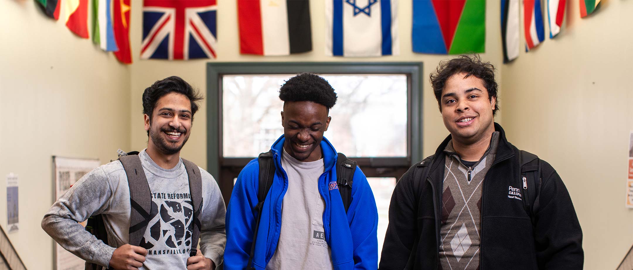 International students standing in front of many international flags