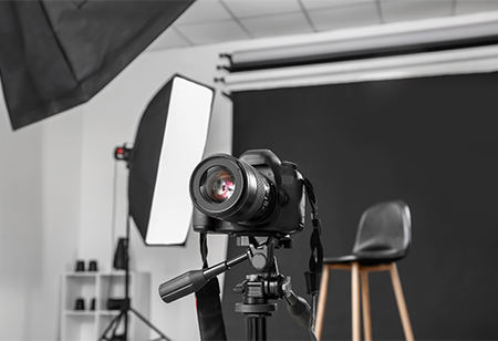 A camera, light, and chair in a photo shoot setting