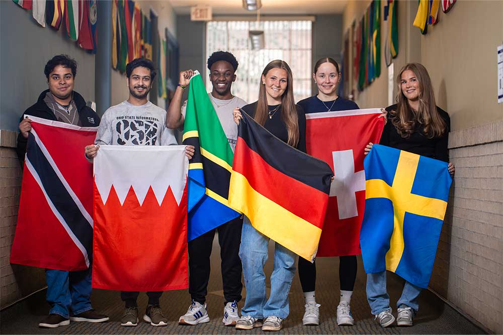 PennWest students display flags representing their home countries, highlighting the university's diverse campus community and global learning opportunities.
