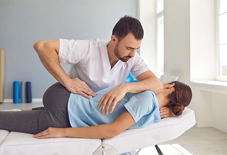 A chiropractor adjusting a patient
