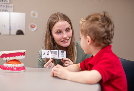 A student helping a child pronounce sounds