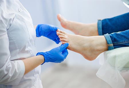 A podiatrist examining feet