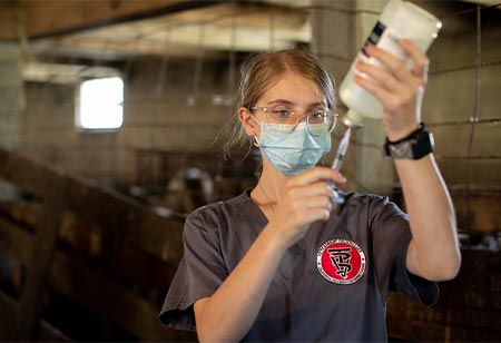 A veterinary student examining a water bottle