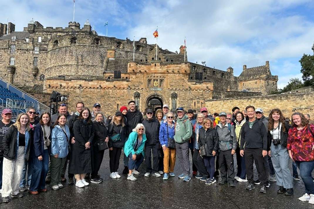 Large group of PennWest study abroad students pose in front of a castle in Scotland.