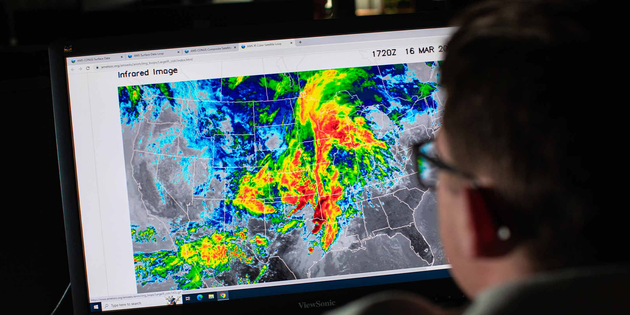 a climate variability and impacts students studying a weather map on a computer screen