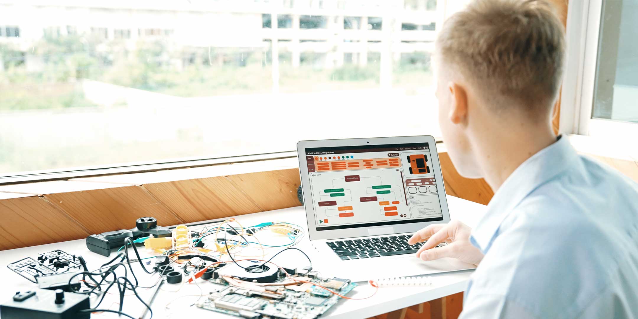 a computer engineering technology student connecting circuit boards to a laptop