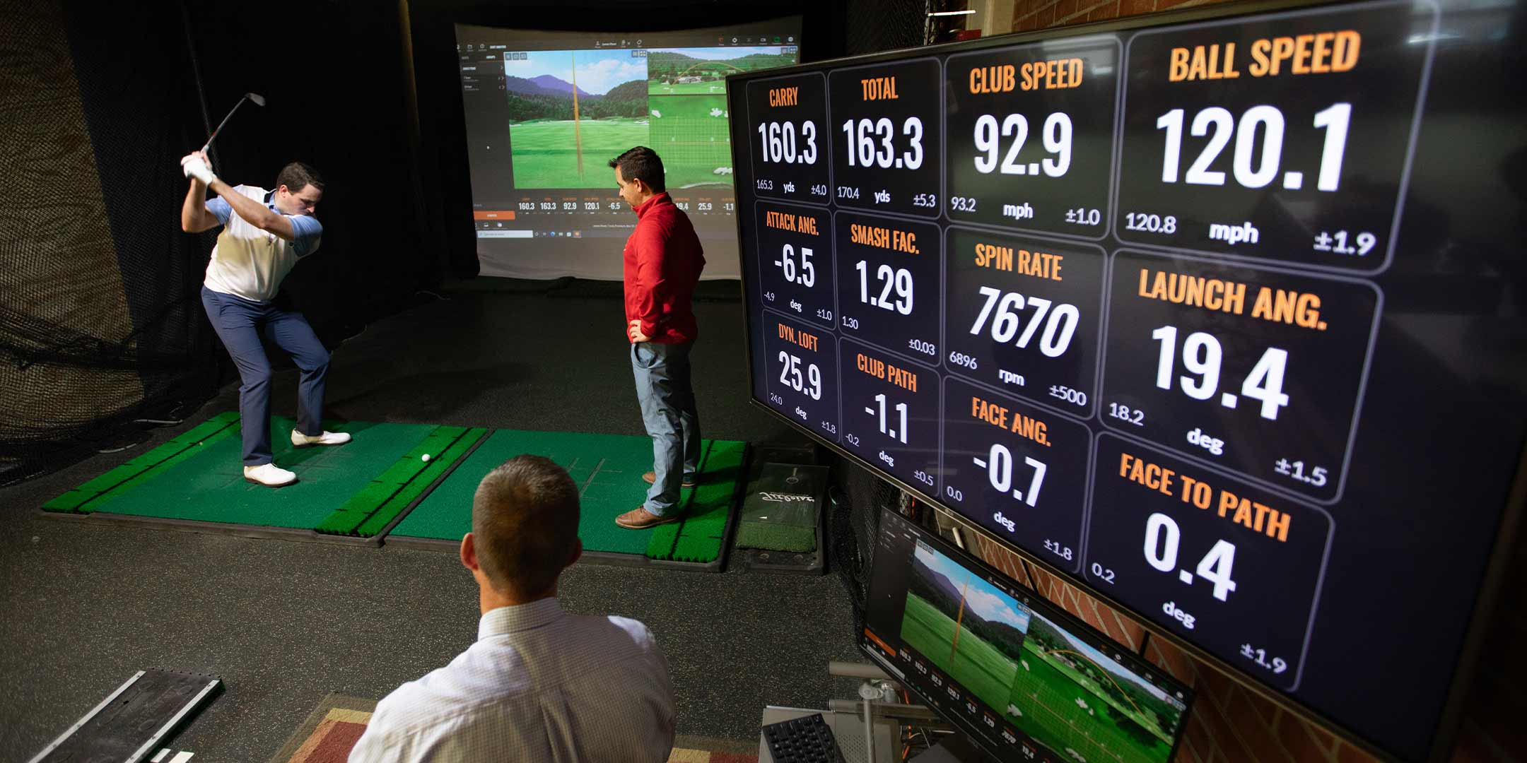 a golf management student learning how to use a golf simulator
