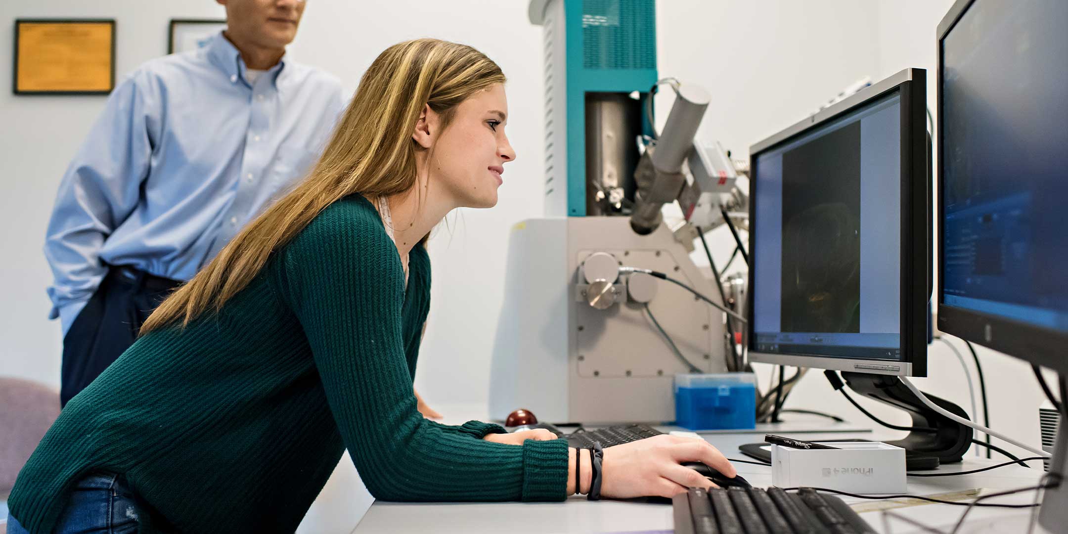 a molecular biotechnology skills student examining a sample under a microscope