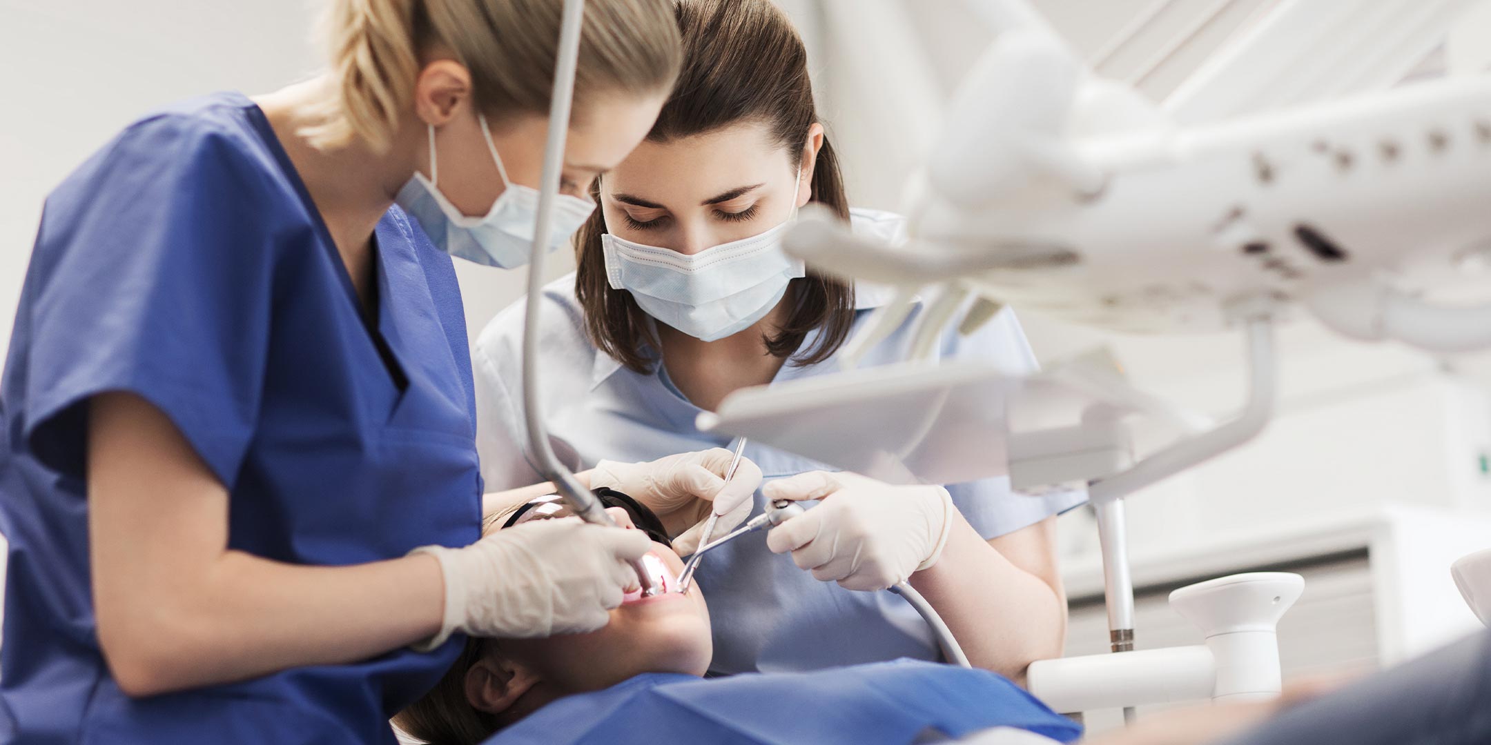 a dentist and a dental assistant caring for a patient