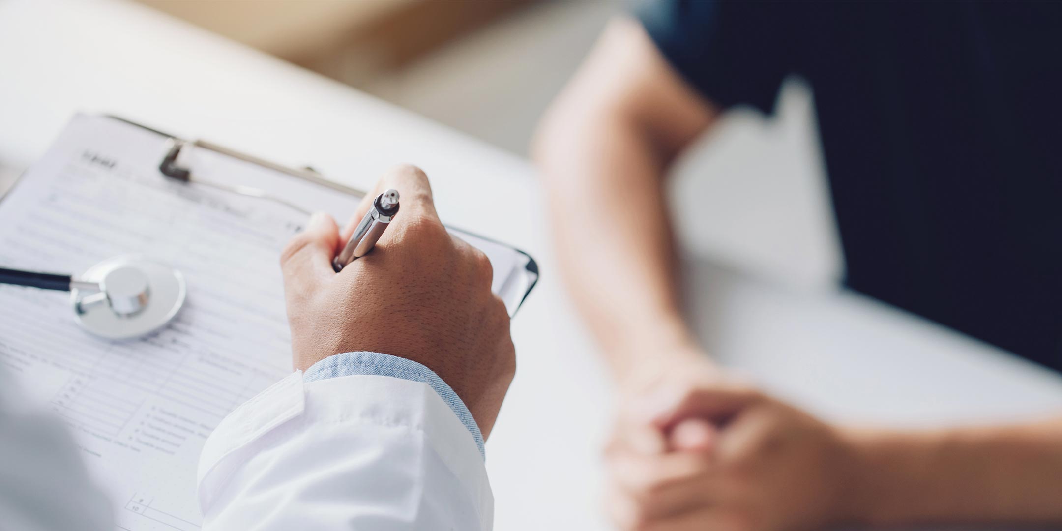 a physician assistant writing a prescription for a patient