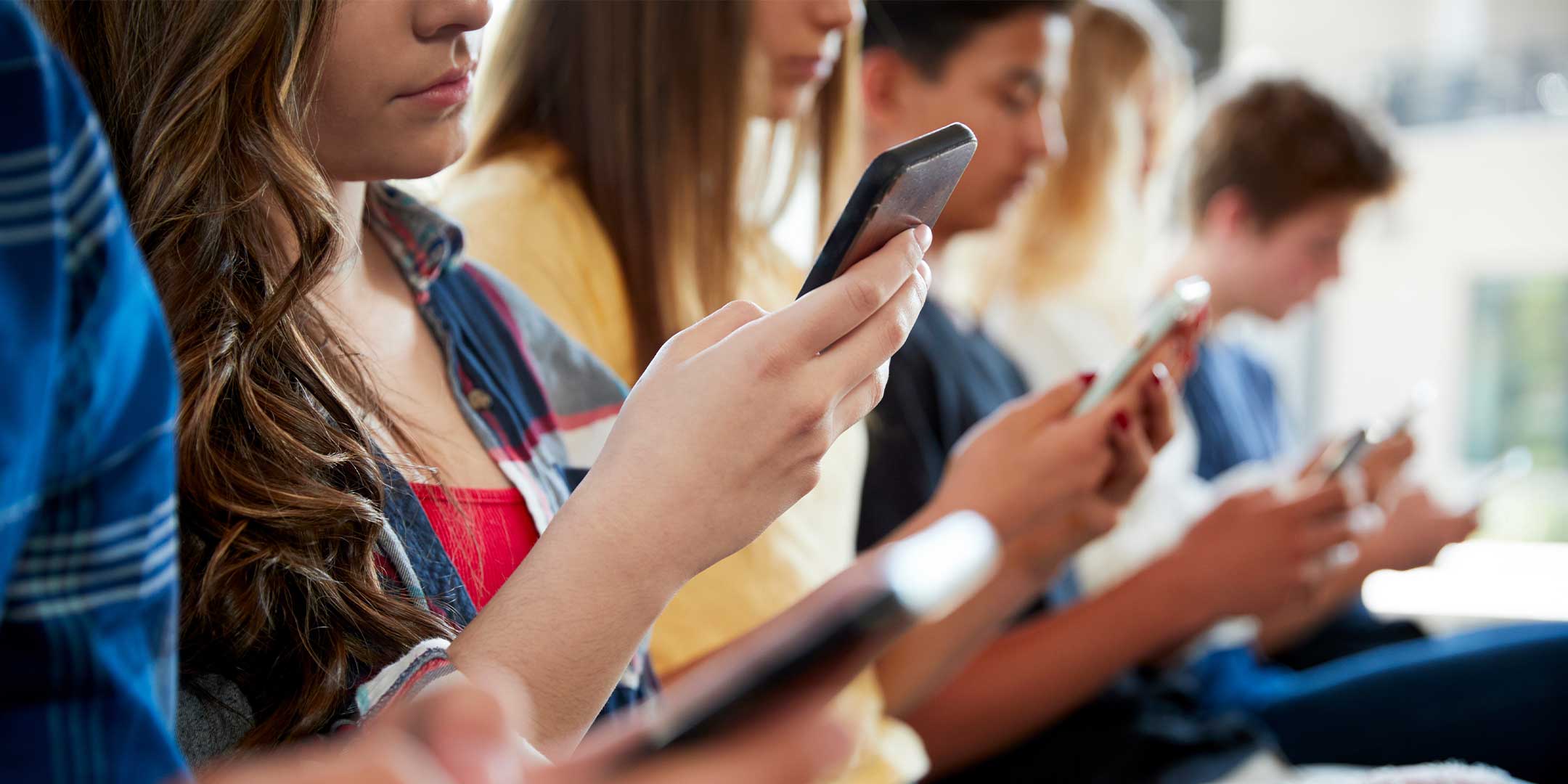 students sitting in a classroom using their cellphones