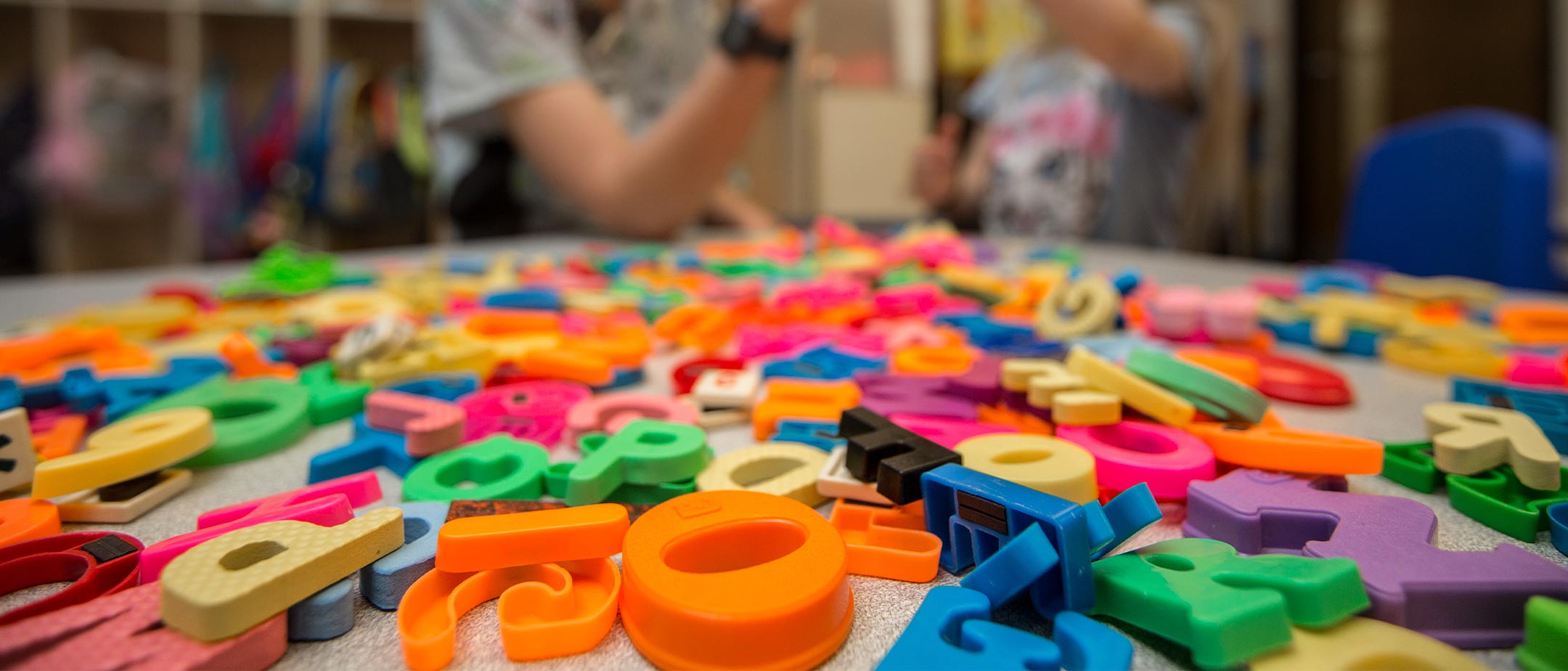 A table with magnetic letters randomly laying on the tabletop