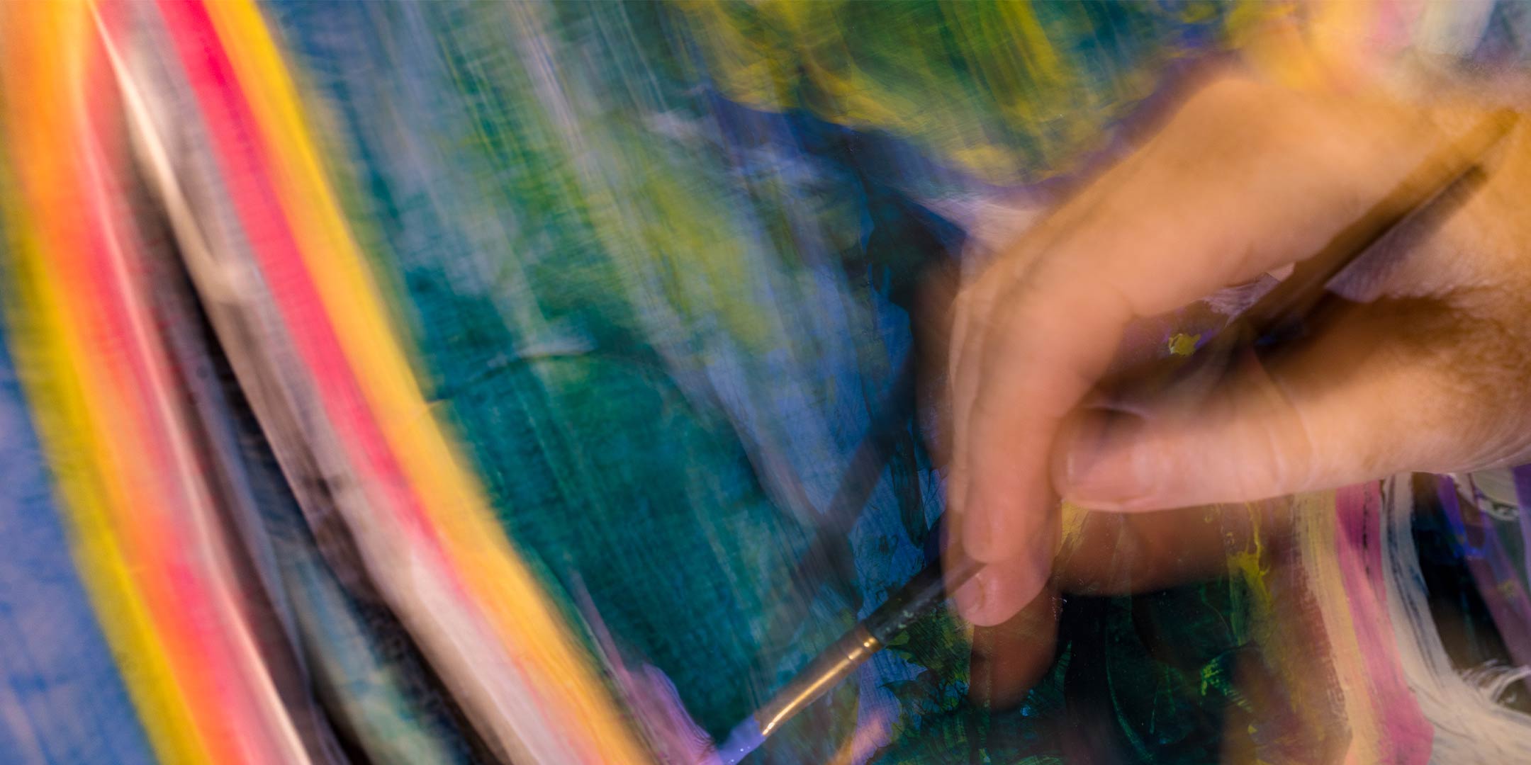a visual art student painting on a canvas