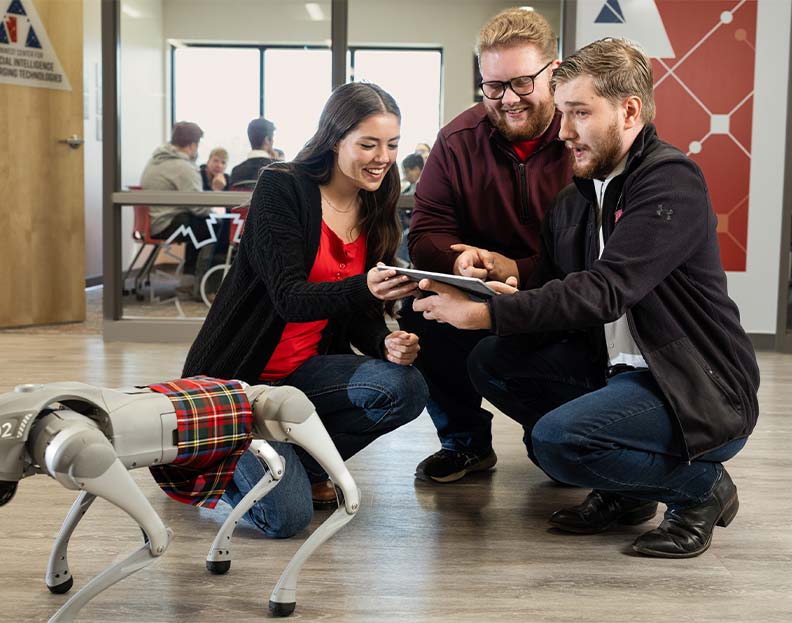 PennWest student learning how to operate a robot dog in the Center for Artificial Intellegence and Emerging Technologies
