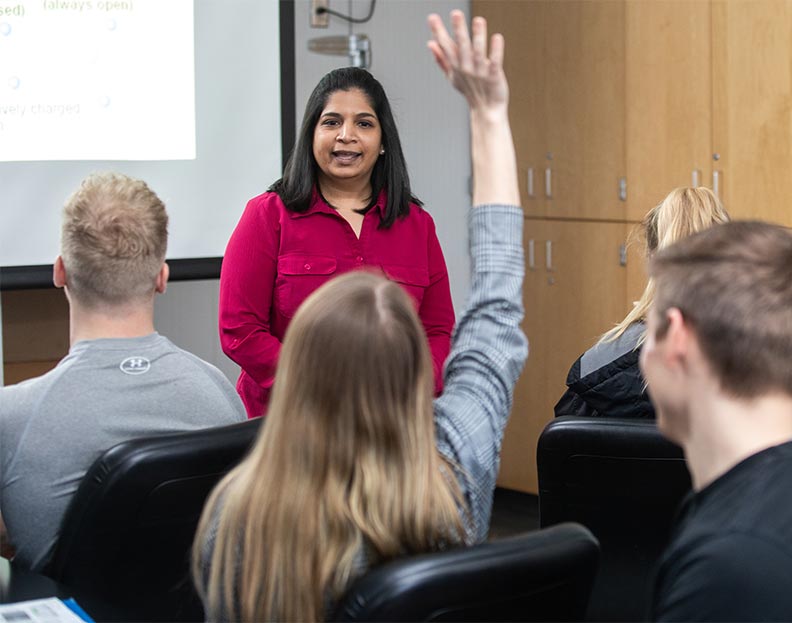 a pre-chiropractic student raising their hand in a lecture class