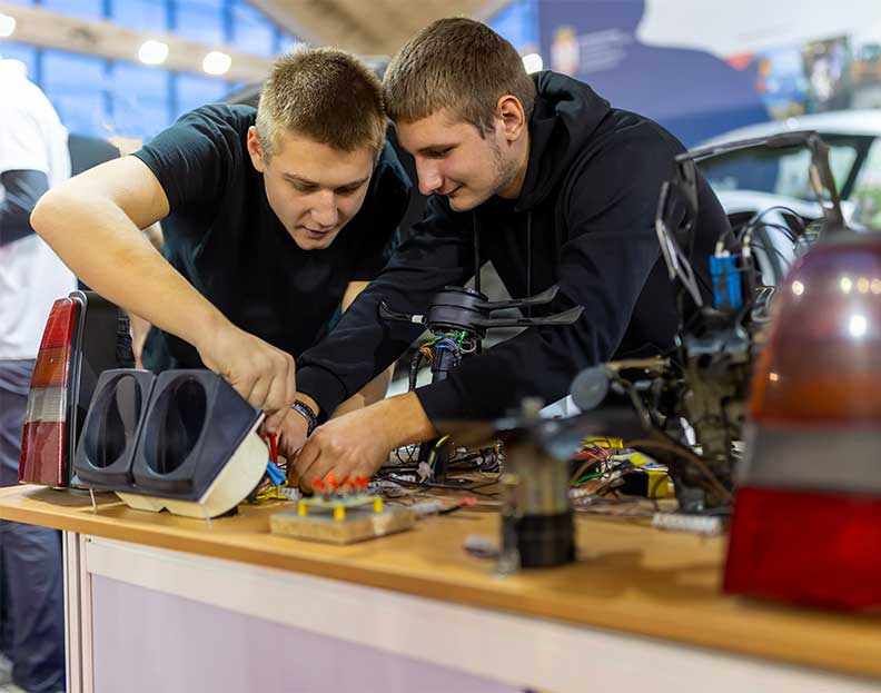 computer engineering technology students working on a circuit board in a lab