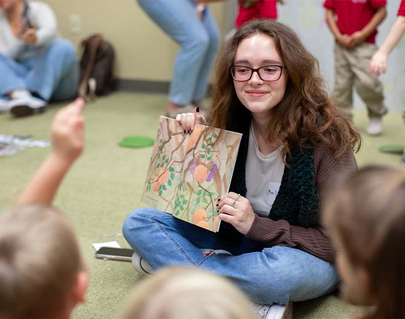 A student teacher helping children learn to read