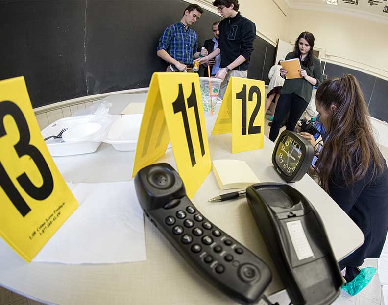 forensic science students reviewing evidence from a mock crime scene