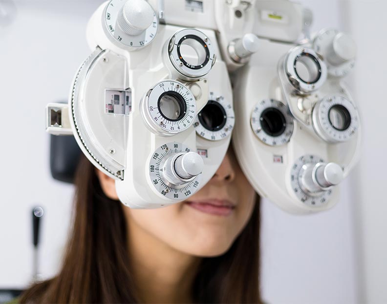 an eye patient looking through a phoropter to determine vision quality
