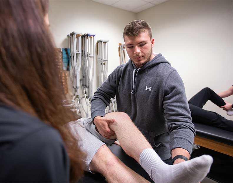 a pre-occupational therapy student examining a student