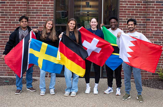 Students holding flags from their home country