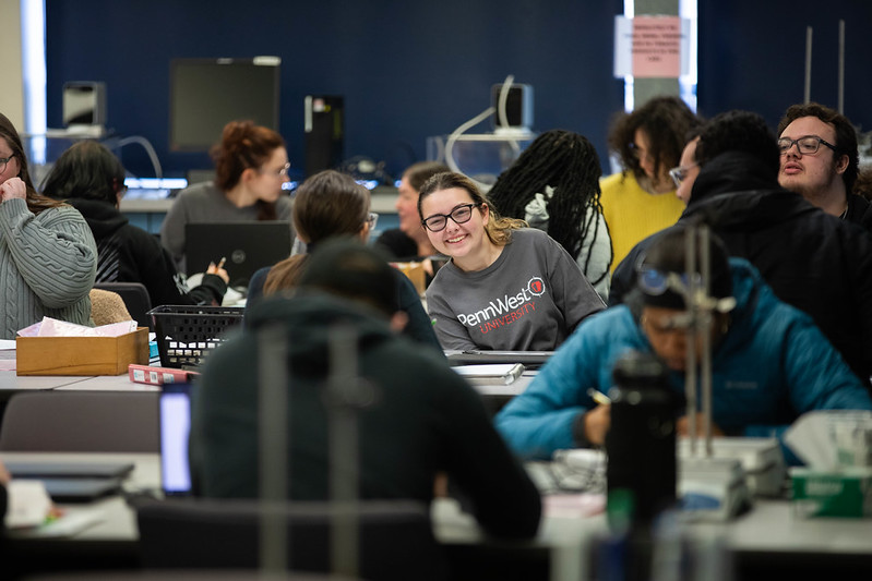 Student smiles while experiencing a college chemistry classroom.