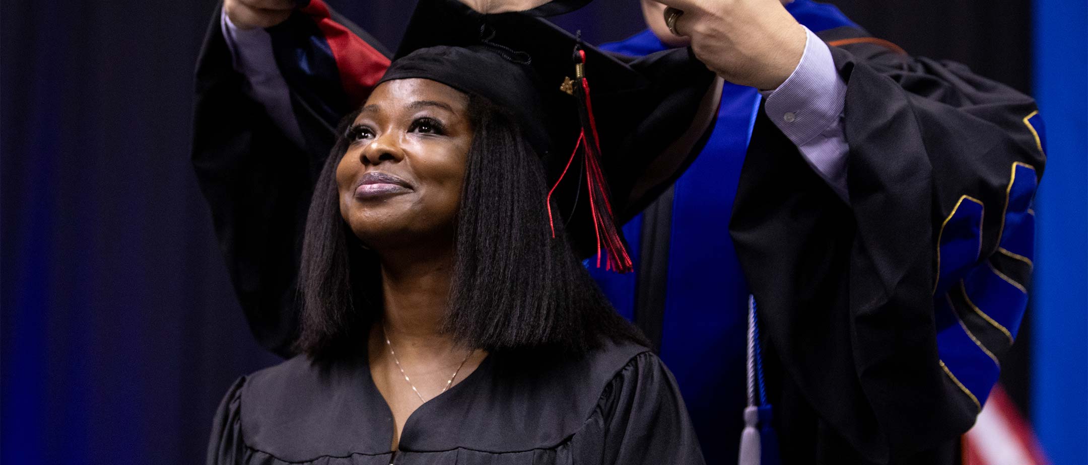 A grad student receiving their hood at graduation