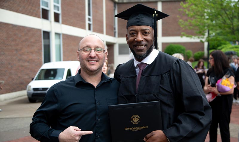 a graduate celebrating with a friend