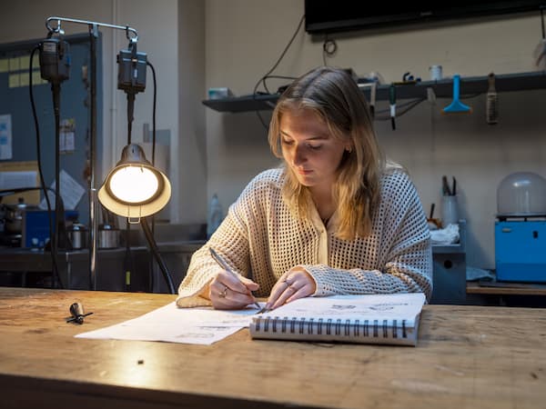 Student working at a table at PennWest University.