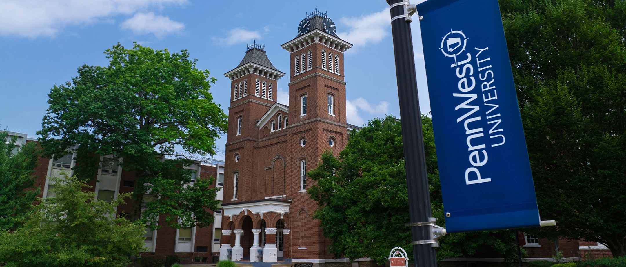 The PennWest flag with the California clock tower