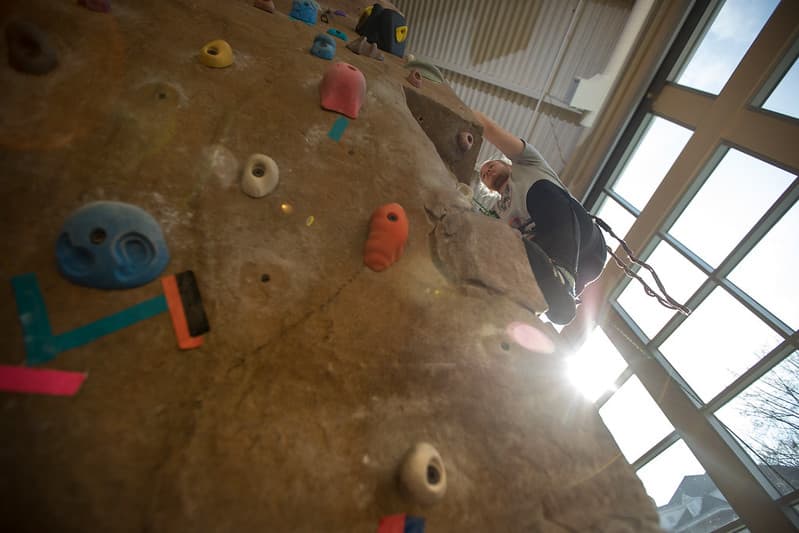PennWest California student climbing the rock wall in Herron Hall. 