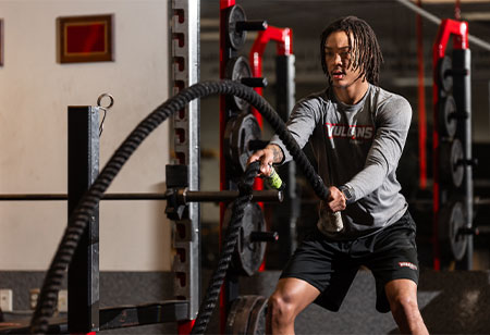 A student exercising with ropes