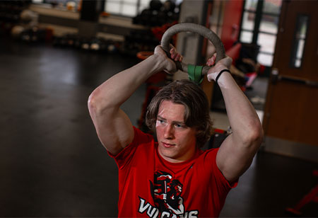 A student exercising with a cable machine