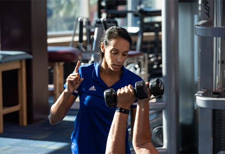 A student exercising with dumbbells