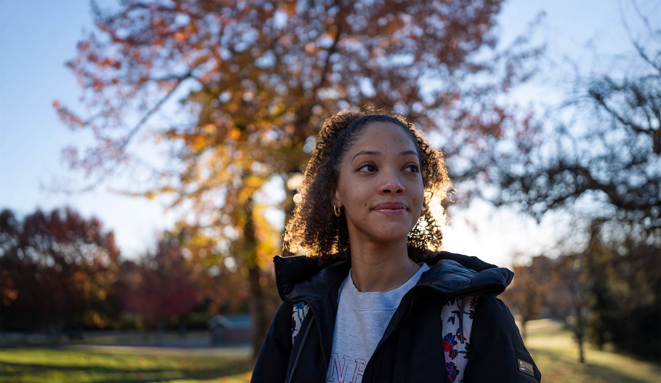A female PennWest student walks across campus on an autumn morning. 