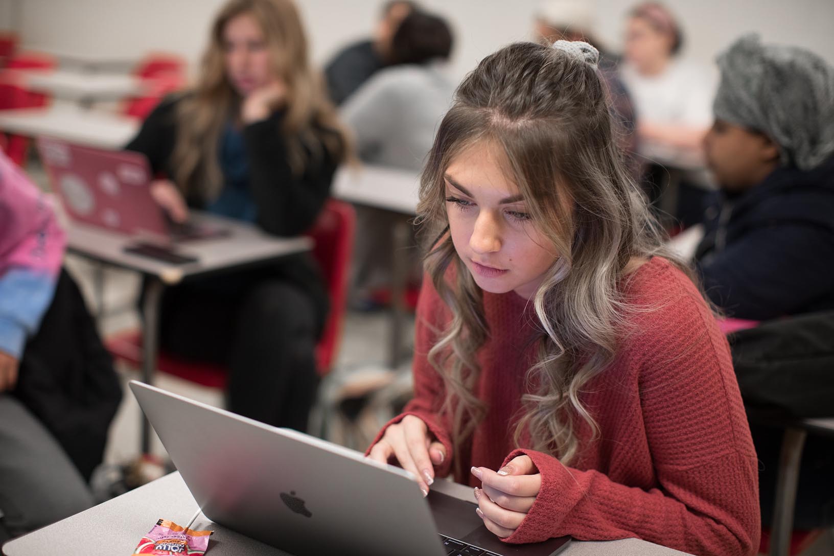 student works on a laptop in classroom