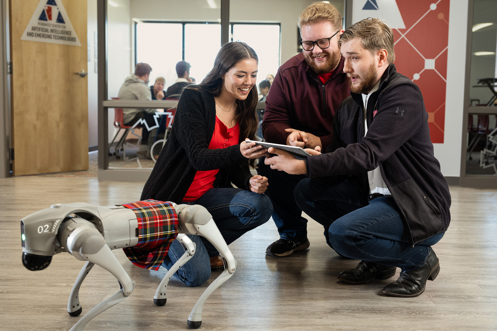 Staff and students interact with the robot dog near PennWest's Center for Artificial Intelligence and Emerging Technologies