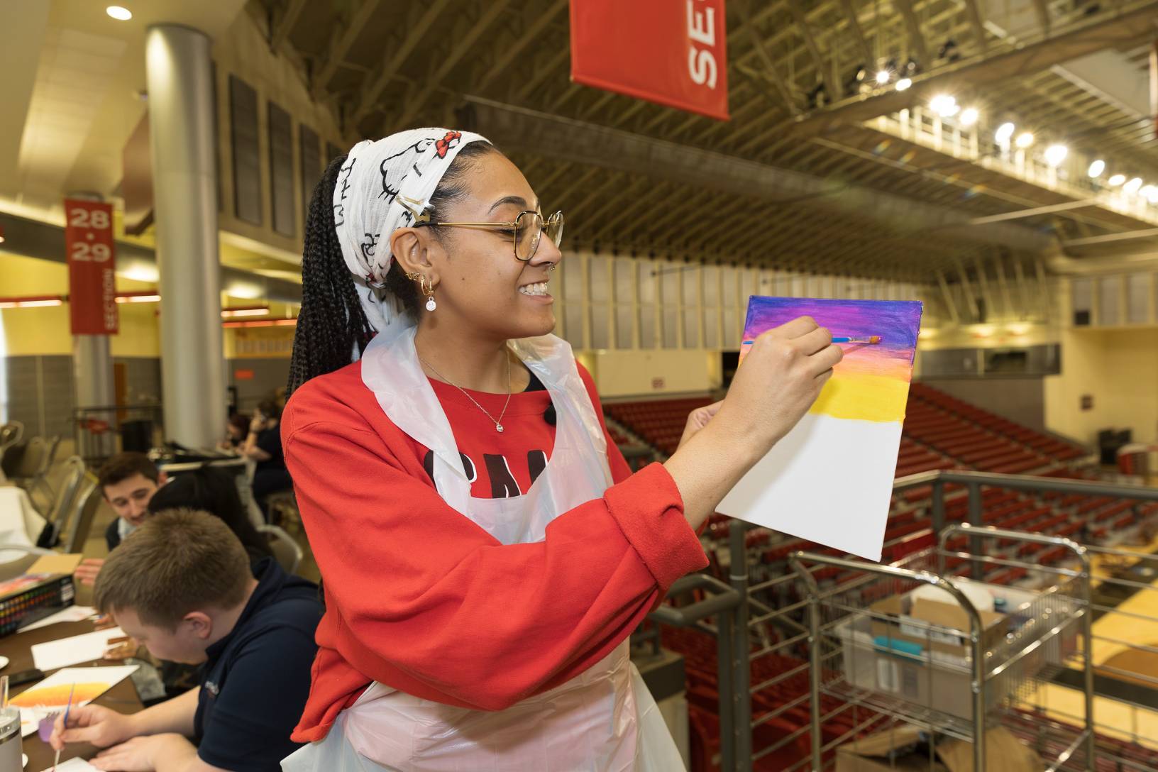 Jaydin King, secondary education – art, leads the group in painting a sunset