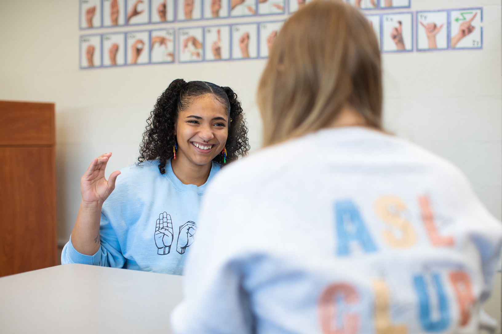 Aryanna Arrington signs to her fellow member of PennWest Edinboro's ASL Club