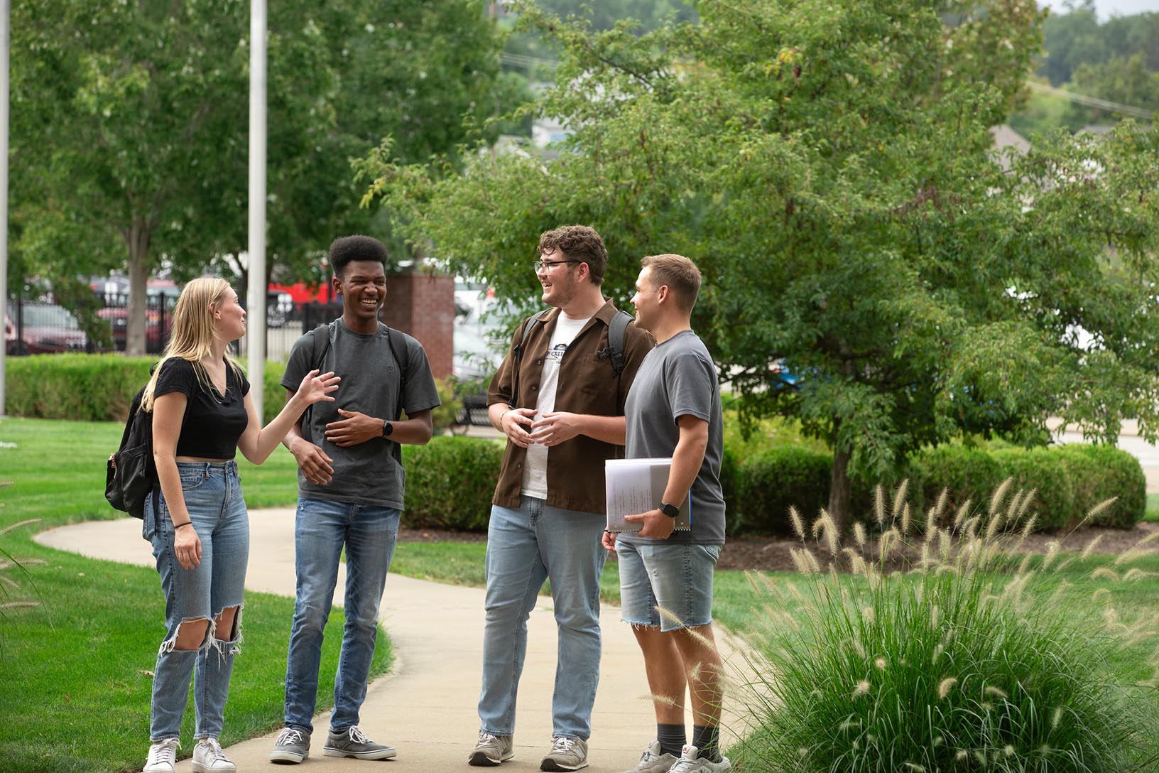 four students stand outside