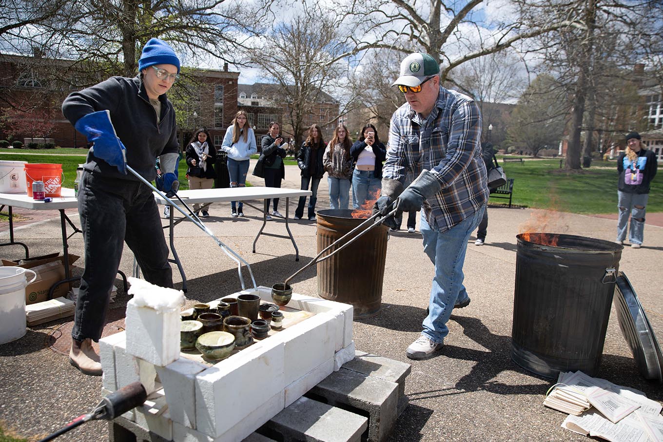 two people work on pottery