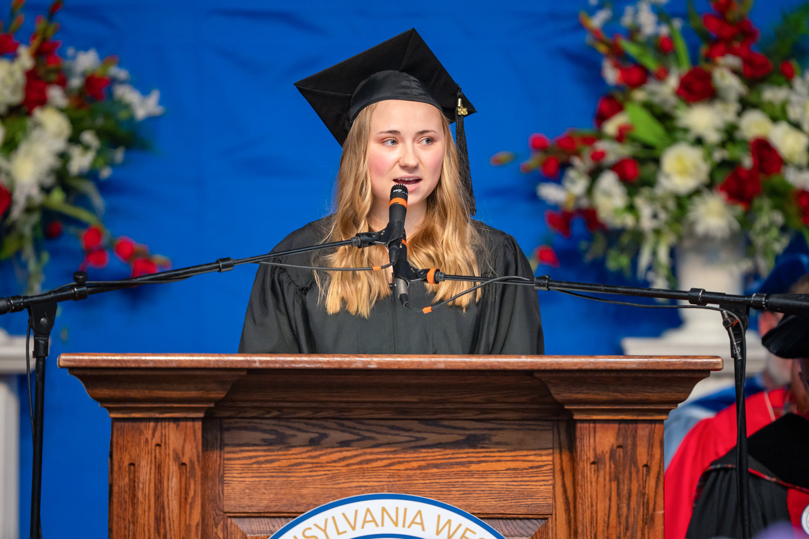 PennWest Edinboro graduate Chelsea Weimer stands at the podium during the spring 2026 commencement ceremony on May 9.