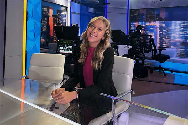 Lauren Bryant sitting in a newsroom. 